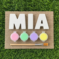 Plaster name kit spelling MIA with four pastel paint pots and a brush