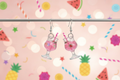 Pink cocktail earrings with festive background